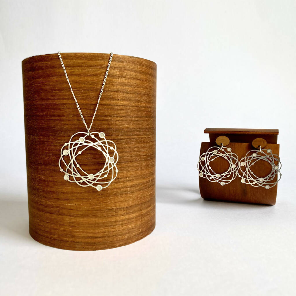 go-do-good-orbit-stud-earrings-and-pendant-necklace-on-wood