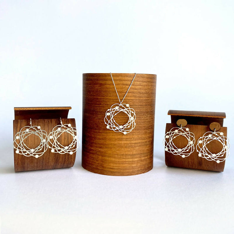 go-do-good-orbit-earrings-and-pendant-family-on-wood